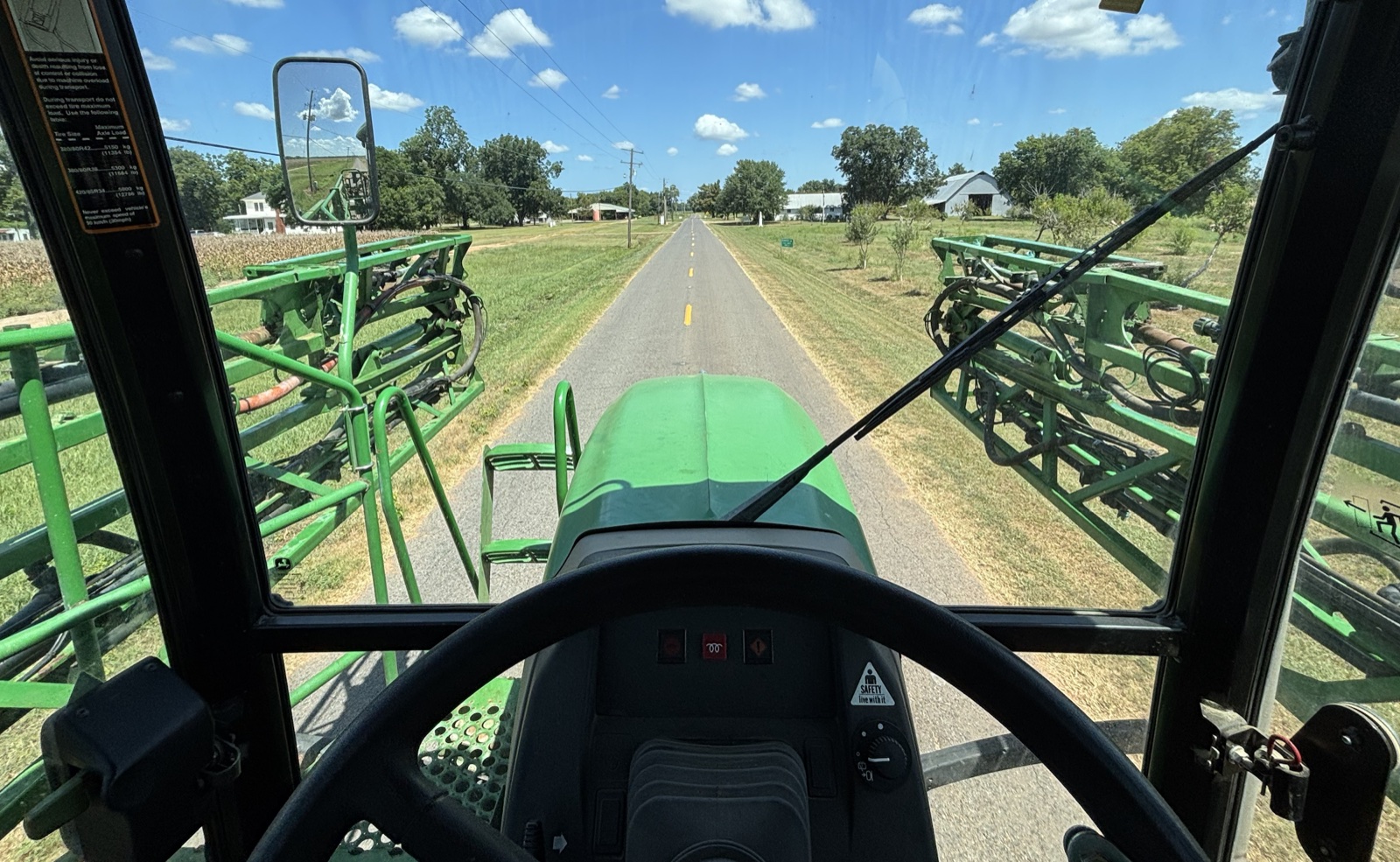 View from inside agricultural equipment on a rural road
